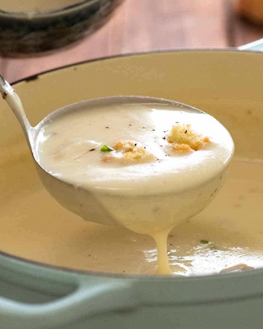 Ladle scooping up thick and creamy Leek Soup from a pot