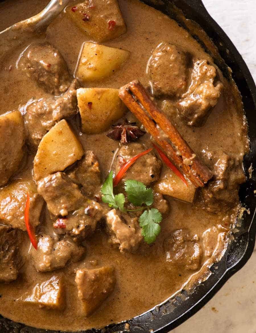 Overhead photo of Massaman Curry in a black skillet, fresh off the stove ready to be served