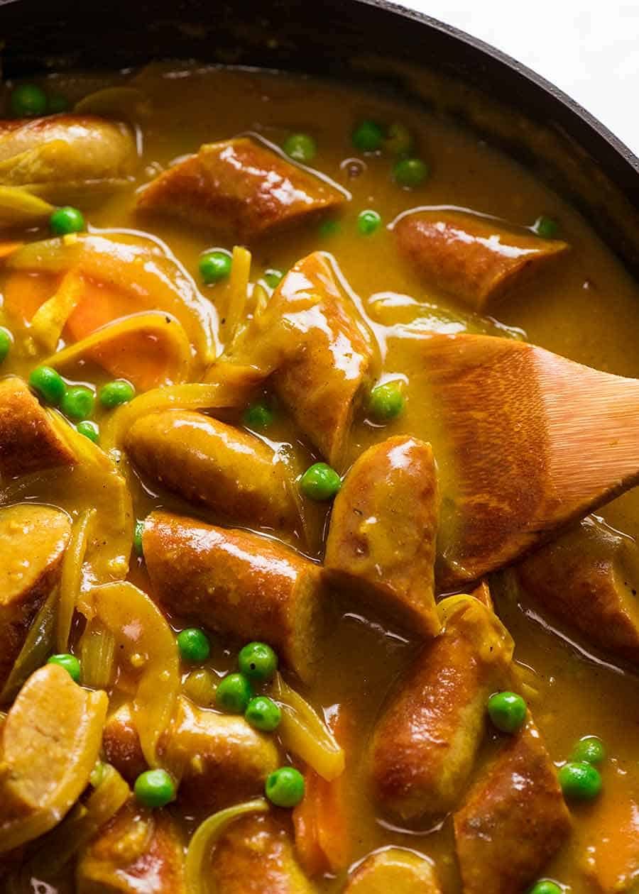 Curried Sausages in a black skillet, fresh off the stove