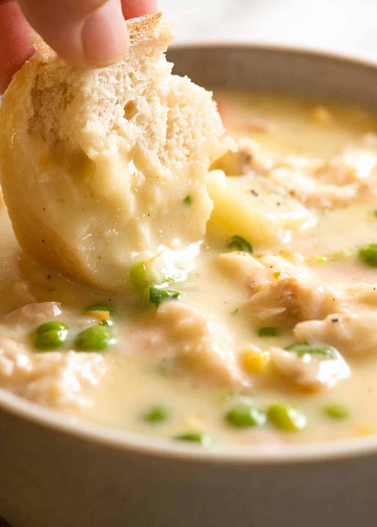 Bread being dunked into Fish Chowder Soup